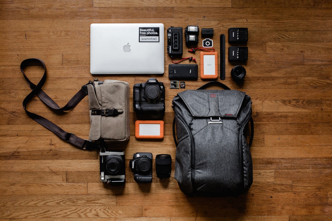 Camera Backpack for Photographers with a mirrorless camera body, two lenses, spare batteries, memory cards, and a compact tripod